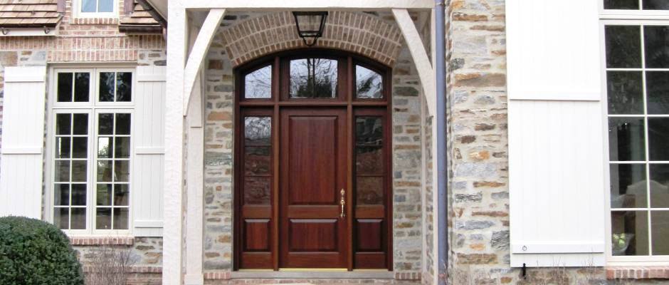 Custom wood entry door with sidelites and arched transom.